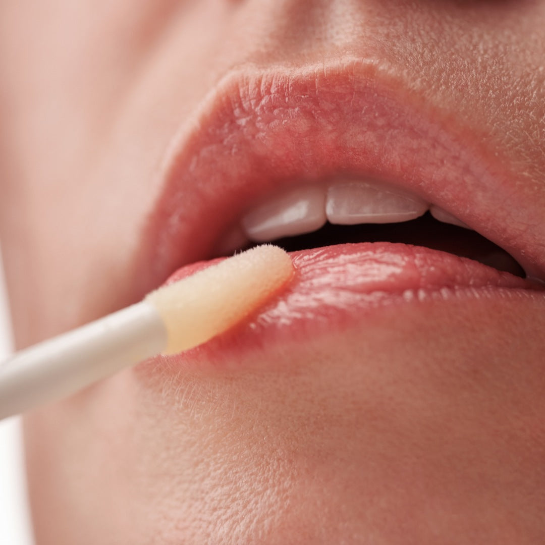 SOS aliejinio serumo lūpoms aplikavimas ant drėgnų lūpų.